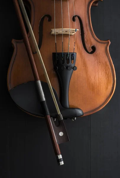 Старая скрипка с бантом на деревянном столе — стоковое фото