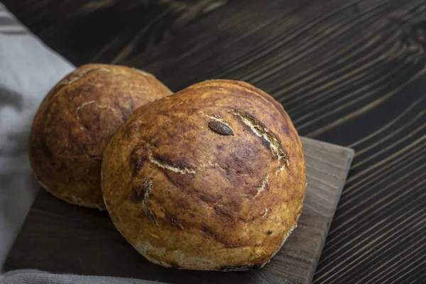 Pão fresco assado na mesa da cozinha escura — Fotografia de Stock