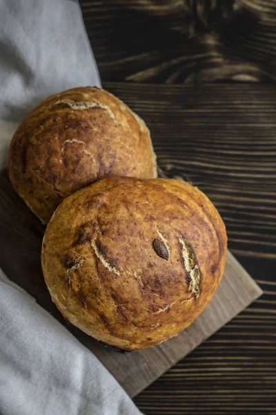 Frissen sült kenyér, sötét konyhaasztalon — Stock Fotó