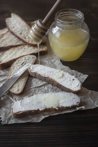 Skivor toast bröd med smör på träbord — Stockfoto