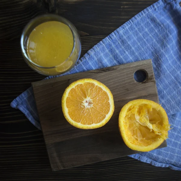 Pomarańcza pokroić na pół na drewnianym stole. — Zdjęcie stockowe