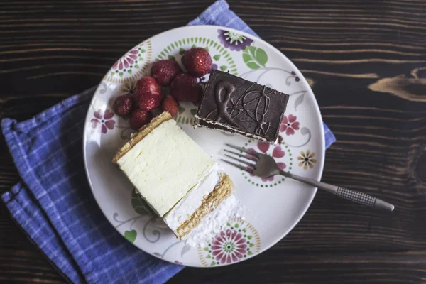 Fatia de bolo de chocolate na placa na mesa de madeira — Fotografia de Stock