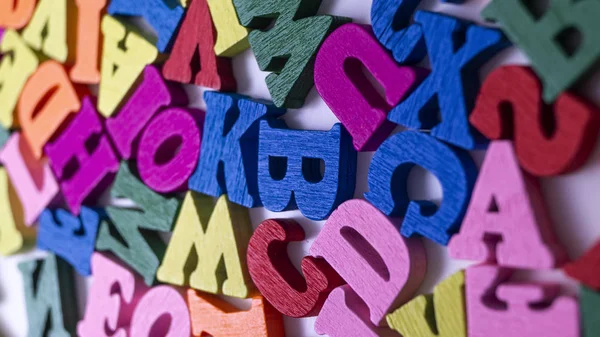 Lettres en bois colorées sur fond en bois Photo De Stock