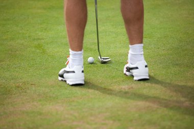 Golf topu ve sopa golfçü bacaklar ile 