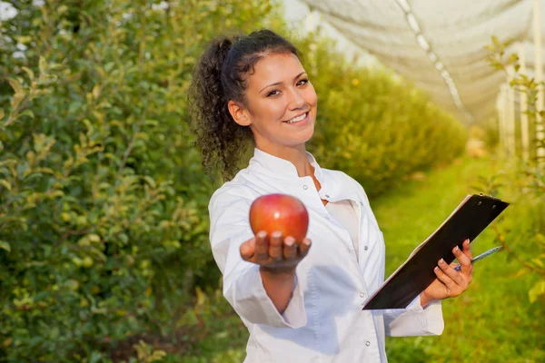 Szczęśliwa młoda kobieta agronom z Czerwone jabłko organiczne w ręku — Zdjęcie stockowe