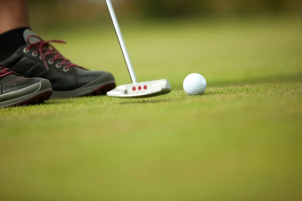Μπάλα του γκολφ και ραβδί με πόδια παίκτη του γκολφ στο παρασκήνιο — Φωτογραφία Αρχείου