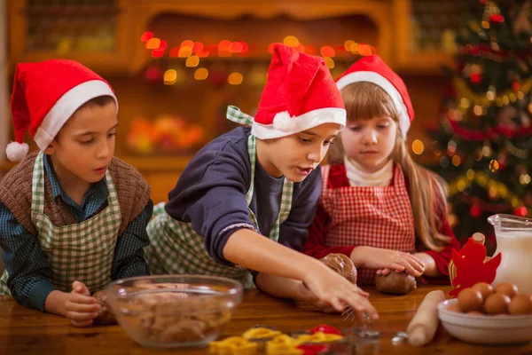 Bonito menino e menina preparando biscoitos de Natal em casa — Fotografia de Stock