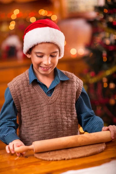 Boy with rolling pin baking in kitchen Christmas cakes — Stock Photo, Image