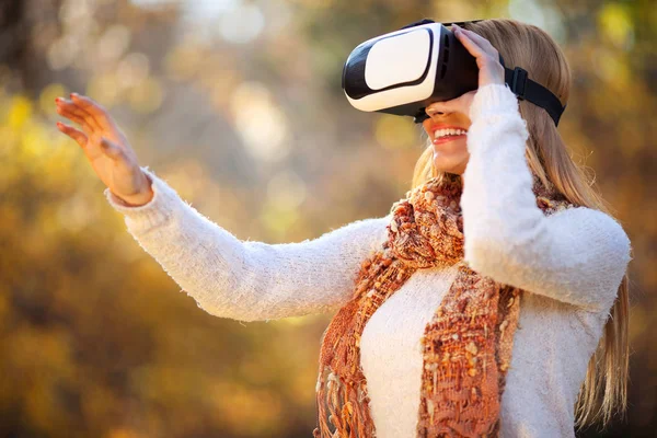 Nők a fehér virtuális valóság fejhallgató pohár őszi parkban — Stock Fotó