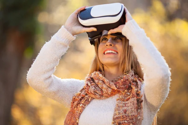 Mulheres usando óculos de realidade virtual branca no parque de outono — Fotografia de Stock