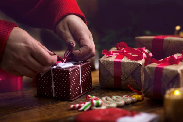 Díszítő karácsonyi ajándékok és díszek nő kezében — Stock Fotó