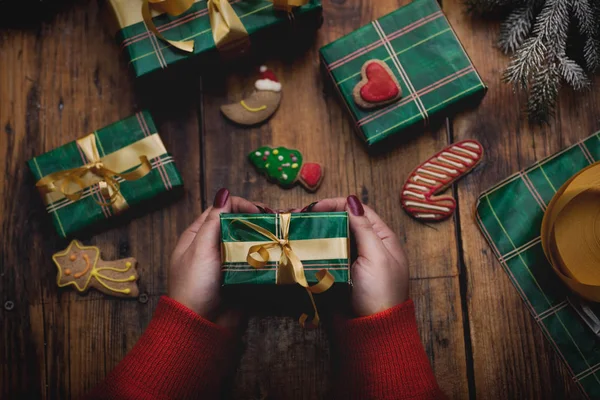 Díszítő karácsonyi ajándékok és díszek nő kezében — Stock Fotó