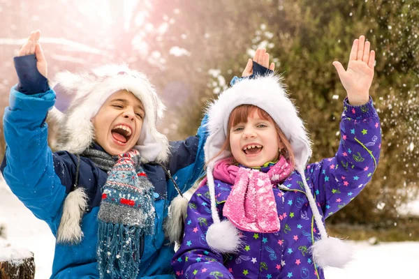 Skrattande barn som leker i snön — Stockfoto