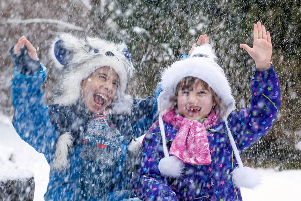 Lachende Kinder beim Spielen im Schneesturm — Stockfoto