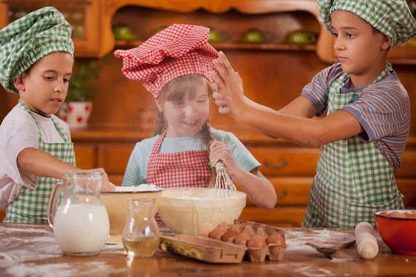 Niños sonrientes haciendo lío en la cocina en casa — Foto de Stock