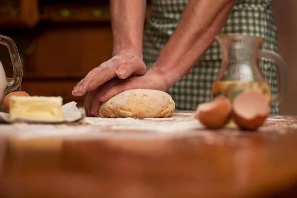 Hombre manos amasar masa en una mesa en su casa cocina —  Fotos de Stock