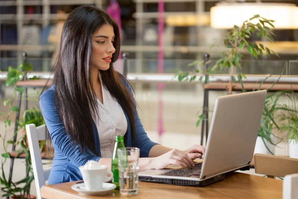 Kobieta pracuje na laptopie w kawiarni — Zdjęcie stockowe