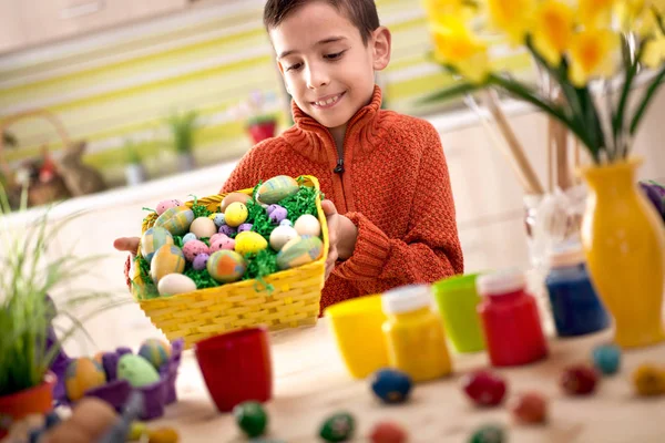 Happy boy holding colorfull Easter basket — Stock Photo, Image