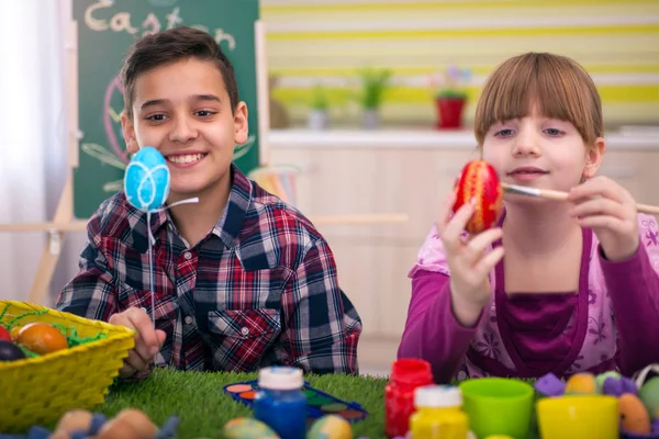 Menino e menina feliz brincando com ovos de Páscoa — Fotografia de Stock