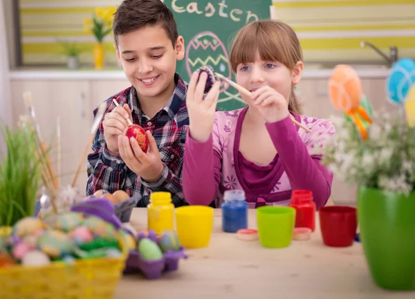 Feliz niño y niña jugando con huevos de Pascua — Foto de Stock
