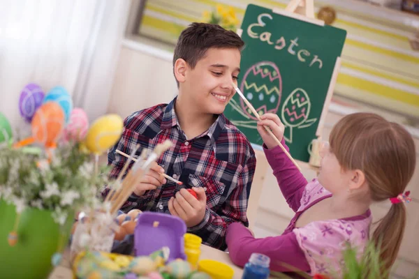 Gelukkige jongen en meisje speelt met paaseieren — Stockfoto