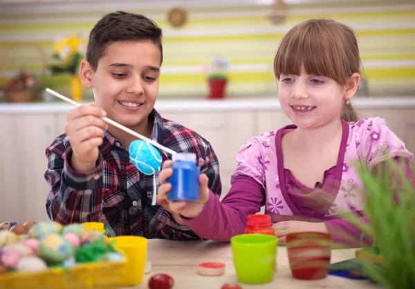 Feliz niño y niña jugando con huevos de Pascua — Foto de Stock