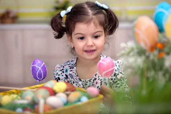 Cute little girl with basket full of colorful easter eggs — Stock Photo, Image