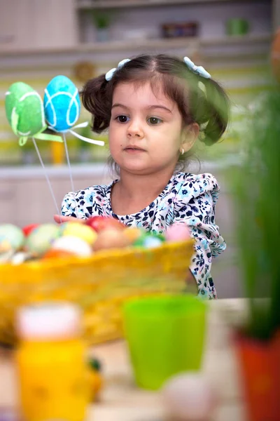 Petite fille mignonne avec panier plein d'œufs de Pâques colorés — Photo