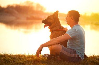 Rahat adam ve köpeği yaz günbatımı veya gündoğumu keyfi