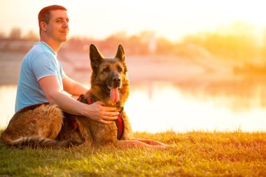Rahat adam ve köpeği yaz günbatımı veya gündoğumu keyfi