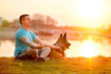 Rahat adam ve köpeği yaz günbatımı veya gündoğumu keyfi