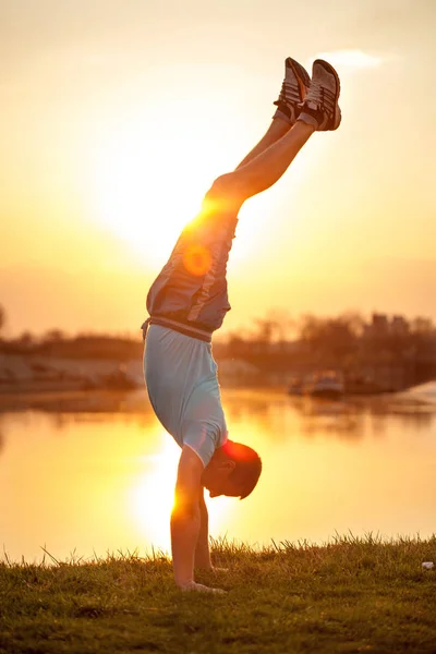 Mann macht Handstand bei Sonnenuntergang — Stockfoto