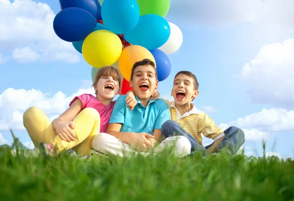 Niños sonrientes felices jugando con globos coloridos —  Fotos de Stock