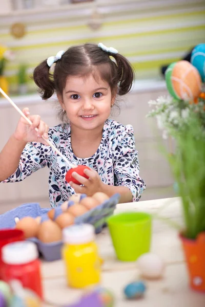 Schattig klein meisje met mand vol kleurrijke paaseieren — Stockfoto
