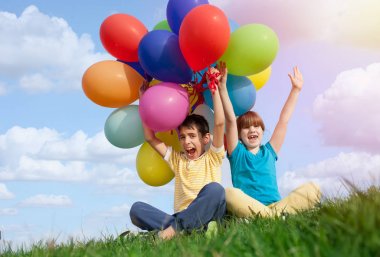 mutlu gülümseyen çocuklar Derma b ile yeşil çim üzerinde yalan