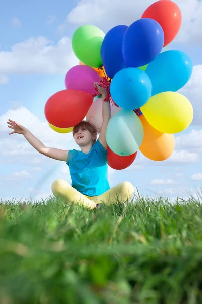 Gelukkig kind spelen met speelgoed van de kleurrijke ballonnen buitenshuis — Stockfoto