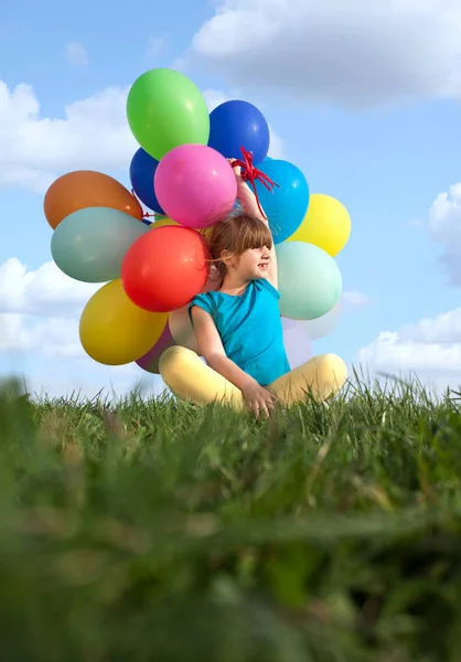 Enfant heureux jouant avec des ballons de jouets colorés à l'extérieur — Photo