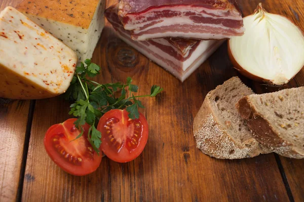 Speck, Käse und Tomaten auf Holzteller — Stockfoto