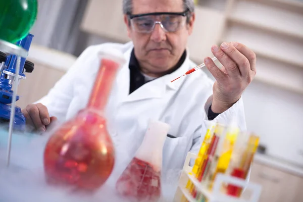 Senior scientist with protective glasess researching in laborato — Stock Photo, Image
