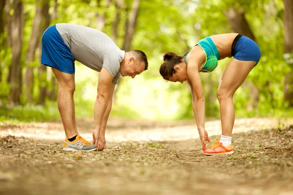 Coppia fitness che si estende all'aperto nel parco — Foto Stock