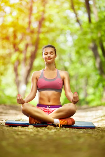 Jeune belle femme en bonne santé fait un yoga dans le parc vert — Photo