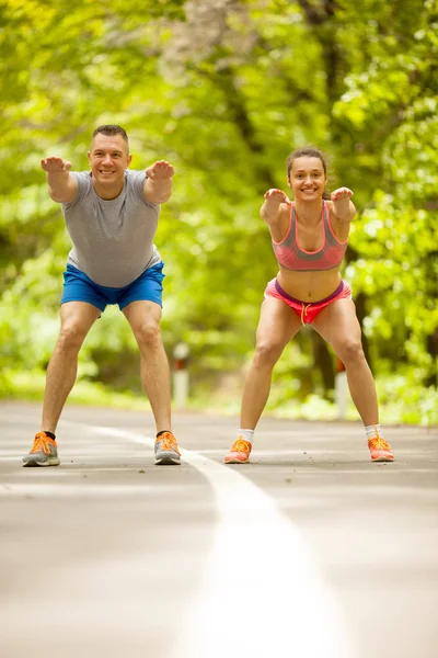 Fitness par sträcker sig utomhus i parken — Stockfoto