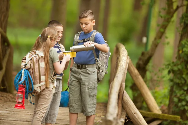 Kids scouts traveler with backpack hiking bridge in forest — Stock Photo, Image