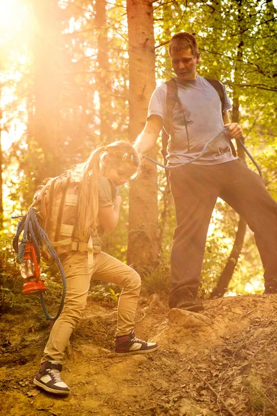 Vater hilft Tochter mit Seil im Wald von der Piste — Stockfoto