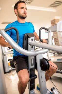 Adam spor salonunda antrenman yapıyor.