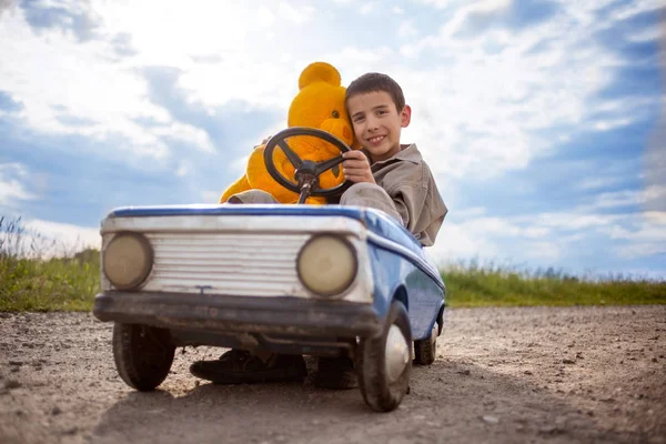 Mladý chlapec jízdy historických hraček auto, Krásný slunečný den — Stock fotografie