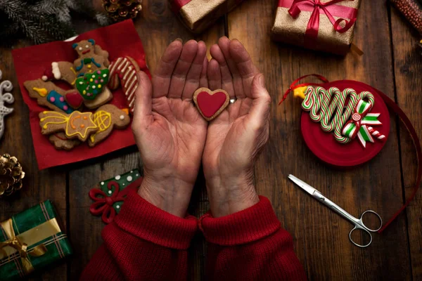 Руки женщины, украшающие рождественские подарки и украшения — стоковое фото