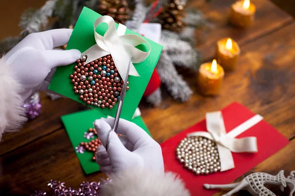 Noel Baba el Noel hediye kutusu ahşap backgrou üzerinde tutarak — Stok fotoğraf