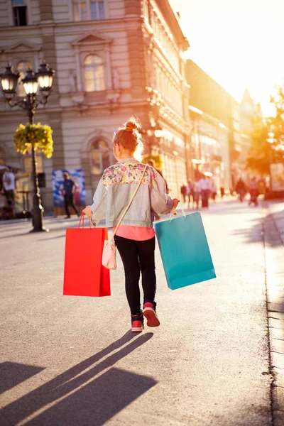 Joven feliz moderna gir divertirse con bolsas de compras en la calle — Foto de Stock