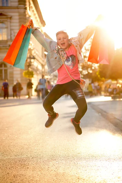 Молодой счастливый современный гир развлекается с сумками для покупок на улице — стоковое фото